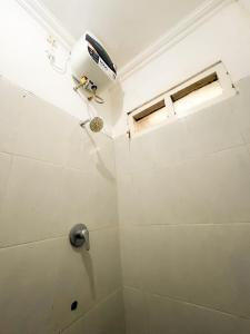 uma casa de banho com chuveiro e luz no tecto em Villa Kamar Tamu Ngestiharjo em Jetis