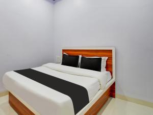 a bedroom with a large white bed with black pillows at OYO Hotel IRA Inn in Aurangabad