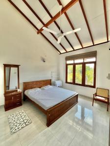 a bedroom with a bed and a table and windows at THE DOCTORS VILLA in Ragama