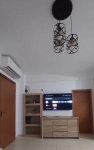 ネオス・マルマラスにあるApartman SIDRO Spacious with BIG balconyのリビングルーム(テレビ、シャンデリア付)