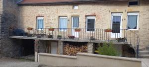 ein Gebäude mit einem Balkon mit Topfpflanzen darauf in der Unterkunft Le cottage du village in Seigny