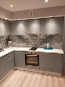 a kitchen with gray cabinets and white counter tops at TheJoy Residence Apartments in Chania Town