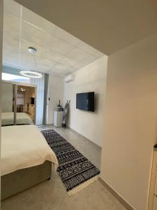 a bedroom with a bed and a tv on a wall at TLux in Stolac