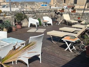 eine Gruppe von Stühlen, Tischen und Stühlen auf einer Terrasse in der Unterkunft Azzurretta Guest House in Lecce