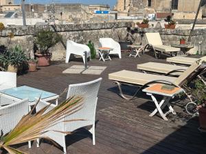un grupo de sillas, mesas y sillas en un patio en Azzurretta Guest House, en Lecce