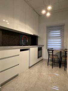 a kitchen with white cabinets and a table in it at TLux in Stolac