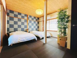 a bedroom with two beds and two potted plants at Rakuyado kyotofushimi II in Kyoto