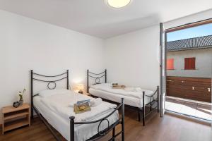 2 Betten in einem Zimmer mit Fenster in der Unterkunft Casa Al Torchio 1,2,3 and 4 - Happy Rentals in Cavergno