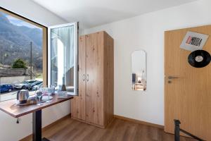Cette chambre dispose d'une table en bois et d'une fenêtre. dans l'établissement Casa Al Torchio 1,2,3 and 4 - Happy Rentals, à Cavergno