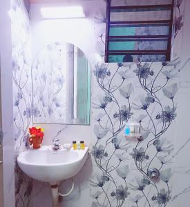 uma casa de banho com um lavatório e um espelho em The Amber em Durgapur