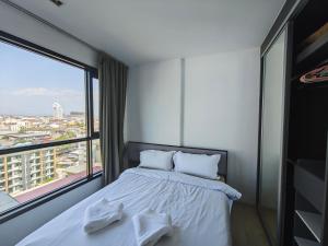 a bedroom with a bed and a large window at The Base Central Pattaya Thai in Pattaya Central