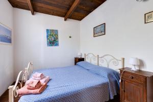una camera da letto con un letto con lenzuola blu e un comò di Il mare in tasca a San Vero Milis
