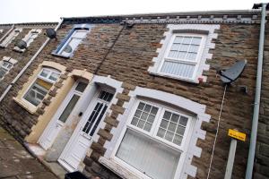 un antiguo edificio de ladrillo con puertas y ventanas blancas en Cosy 3BR Home, Scenic Views, Ideal for Walks & Work, en Abertillery