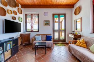ein Wohnzimmer mit einem Sofa und einem TV in der Unterkunft Il mare in tasca in San Vero Milis