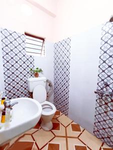 a bathroom with a white toilet and a sink at The Amber in Durgāpur
