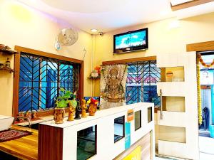 a living room with a tv and stained glass windows at Jo'stel Amber in Durgāpur