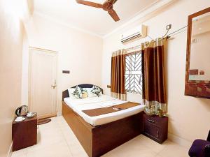 a bedroom with a large bed and a window at The Amber in Durgāpur