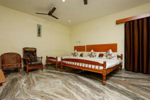 a large bedroom with a bed and a chair at Hotel Hara Rama Hare Krishna Rameswaram in Rāmeswaram