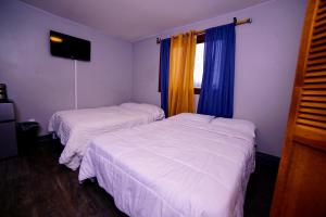 two beds in a hotel room with a window at Cozy Private Room With Two Beds in Anchorage