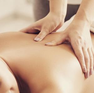 a woman getting a back massage from a therapist at Ferienwohnung Kohl - Dachlmoos in Bischofswiesen