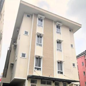 een groot wit gebouw met ramen bij OYO 93808 Lincoln Dormitory in Tangerang