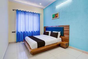 1 dormitorio con 1 cama con pared azul en OYO HOTEL STAY INN, en Haldwāni