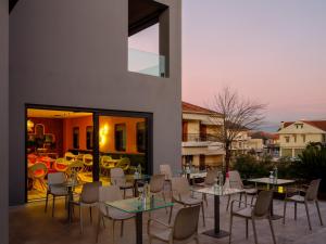 un patio con tavoli e sedie su un balcone di Essence Hotel a Ioannina