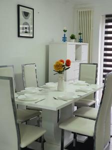 a white table with chairs and a vase with flowers at 1. Single Room (Professional, Trades) Welcome in Luton