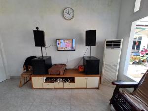- un salon avec une télévision et des haut-parleurs sur le mur dans l'établissement OYO 93814 Amanda Homestay, à Bandar Lampung