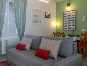 sala de estar con sofá gris y almohadas rojas en Mamma Ciccia - modern apt in the historic centre, en Mandello del Lario