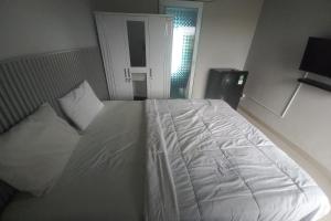 A bed or beds in a room at Capital O 93816 Cerry Village