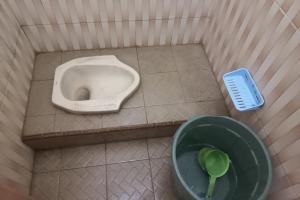 - une salle de bains avec un urinoir et un bol avec une brosse dans l'établissement SPOT ON 93815 Chimi Rumah Kost, à Purwokerto