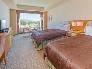 a hotel room with two beds and a television at LiVEMAX RESORT Hakodate Greenpia Onuma in Mori