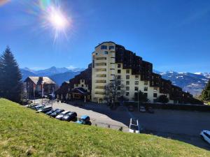 a large building with cars parked in a parking lot at Alpine Luxury Suite Beatenberg in Beatenberg