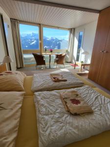 a bedroom with two beds and a table with a view at Hotelwohnung Superior-Suite in Beatenberg