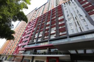 a tall building with red and white at OYO 93825 Nona Key Property in Bekasi