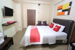 a bedroom with a large bed with red pillows at OYO 93825 Nona Key Property in Bekasi