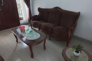 een woonkamer met een bank en een salontafel bij OYO 93820 Salma Homestay Syariah in Purwokerto