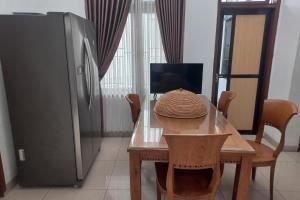 a table with a straw hat on it next to a refrigerator at Hotel O Salma Homestay Syariah Near alun alun kota purwokerto in Purwokerto +19 photos