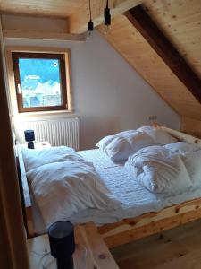德哥米斯的住宿－Nähe Talstation Turracher Höhe, Ferienwohnung in urigem Holzhaus - b60702，一间卧室配有一张带白色床单的床和一扇窗户。