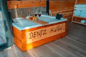 a bath tub in a room with two glasses of wine at Denizkuşu Bungalov in Rize