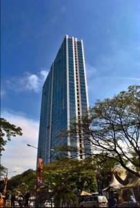 een hoog glazen gebouw met auto's voor het gebouw bij OYO 93826 Cprc Inn Serpong in Tangerang