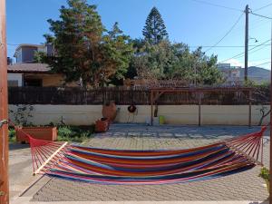 a hammock on a patio in a yard at Golden Horizon Retreat, 2 min walk from the sea! in Gournes