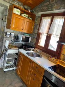 a kitchen with a sink and a microwave at MANOLIS COTTAGE THANOS in Thános +21 photos