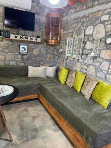 a couch in a room with a stone wall at MANOLIS COTTAGE THANOS in Thános