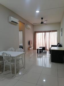 a living room with a white table and chairs at Enjoy the sunset @ Bright mesahill condo in Nilai +10 photos
