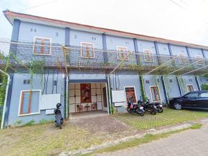 a blue building with motorcycles parked in front of it at OYO 93837 Ipeda Family Residence in Banyuwangi