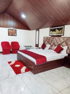 een slaapkamer met een groot bed met rode kussens bij Shiva Green Valley Farms in Bikaner