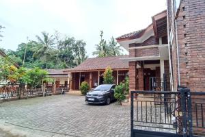a car parked in front of a house at OYO 93839 Aquenda Homestay in Yogyakarta