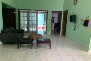 un soggiorno con divano, sedie e tavolo di OYO 93839 Aquenda Homestay a Yogyakarta